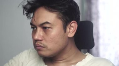 Beyaz gömlek giyen bir adam bir parça ekmek yerken gözlerini tam karşıya odaklıyor. Görüntüler doğal bir yeme ve konsantrasyon anı yakalıyor. Stok için uygun. 4K