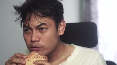 Ekmek yerken beyaz gömlek giyen evsiz bir adamın yakın plan fotoğrafı. Görüntüler yüz ifadesini ve duygularını yansıtıyor. Açlığı, mücadeleyi ve insan direncini yansıtıyor. Stok için uygun 