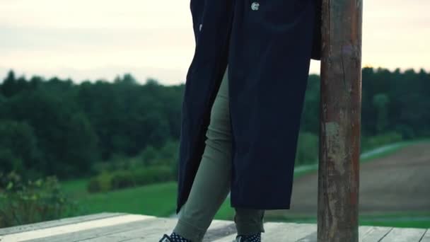 Una Chica Con Abrigo Largo Negro Con Zapatillas Deporte Pie — Vídeos de Stock