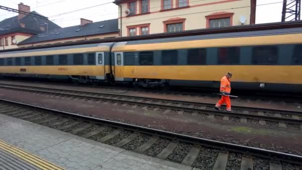 Vonatmérnök Egy Tükröződő Narancssárga Mellényben Sétál Sínek Mentén Állomáson Indulás — Stock videók