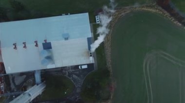 Elektrik ve ısı üreten kömür yakan fabrikanın havadan görünüşü. Fabrika bacasından beyaz duman geliyor. 4k