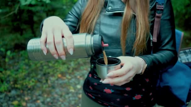 森で紅茶を楽しむ 森の女性は自分自身のために休憩し お茶を注ぐ — ストック動画