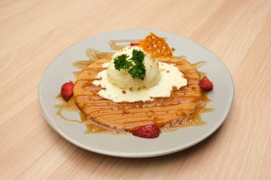 Vanilyalı krep, karamel sosu ve çilekli.