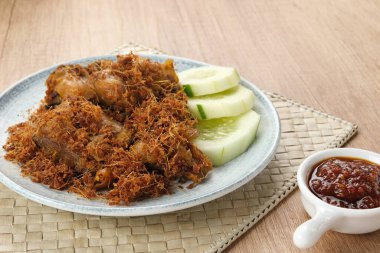 Ayam Goreng Lengkuas, baharatla pişirilmiş kızarmış tavuk ve rendelenmiş galangal serpiştirilmiş. Endonezya geleneksel yemekleri.  