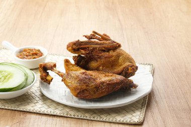 Bebek Goreng, acı sos (sambal) ve salatalık ile servis edilir. Endonezya yemekleri