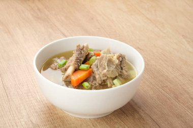 Sop Iga (sığır pirzolası çorbası) pirzola, havuç ve pırasadan yapılır. Beyaz kasede servis edilmiş. Endonezya yemekleri