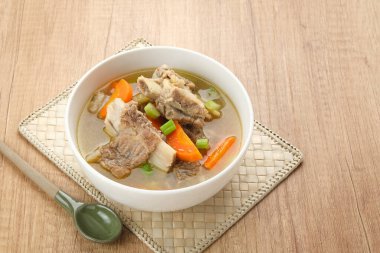 Sop Iga (sığır pirzolası çorbası) pirzola, havuç ve pırasadan yapılır. Beyaz kasede servis edilmiş. Endonezya yemekleri