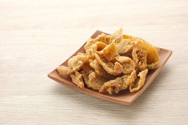 Tabakta kızarmış tavuk derisi (Kulit Ayam Krispi) servis ediliyor