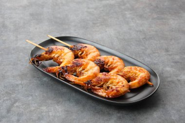 Udang Bakar Madu, ballı ızgara karides, acılı sos, biber ve ballı karides.