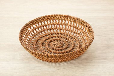 Ahşap arka planda boş rattan hasır sepet. Kapat.