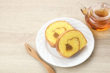 Bolu Gulung Nanas veya Pineapple Roll Keki beyaz tabakta servis edilir.