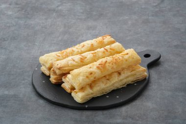 Peynir Çubuğu Pastası doğrama tahtasında servis ediliyor.