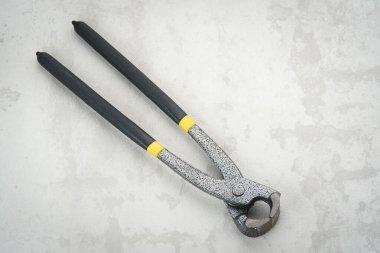 Siyah lastik saplı metal pense.