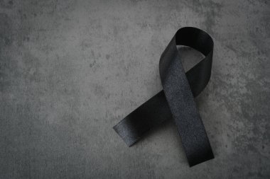 Siyah saten kurdele koyu arkaplanda izole edilmiş. 