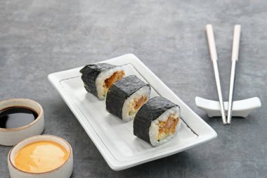 Beyaz tabakta servis edilen suşi ruloları..