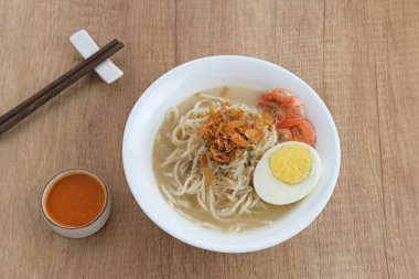 Mie Celor, a noodle dish from Palembang, South Sumatra, Indonesia. Served in a thick and savory shrimp broth with complements such as eggs, shrimp, bean sprouts, and celery. clipart