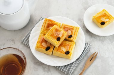 Lekker Holland ya da Hollanda usulü tereyağlı kek (boterkoek), tereyağı, un, yumurta ve şekerden yapılmış, dilimlenmiş badem ve kuru üzüm serpiştirilmiş.