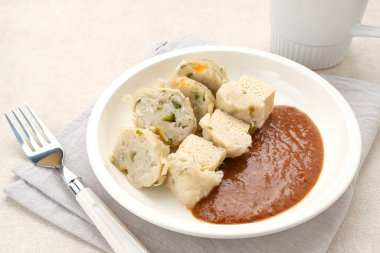 Siomay Bandung (Shumay) or steamed dumplings with boiled tofu. Indonesian traditional street food with peanut sauce. clipart