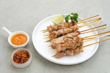 Sate Taichan, kızarmış tavuk, fıstık sosu ve soya sosu olmadan. Tabakta sambal (acılı sos) ile servis edilir.). 