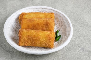 Risoles Rogout, Indonesian traditional savory snack. Filled with chicken chopped and mix vegetable, covered with bread crumb and deep fried. Served in white plate with chilli. clipart