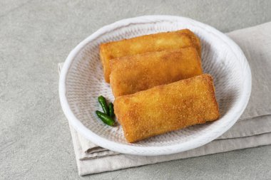 Risoles Rogout, Endonezya 'nın geleneksel lezzetli atıştırmalıkları. Tavuk pirzolası ve sebze karışımı, ekmek kırıntısı ve bol yağda kızartılmış. Kırmızı biberli beyaz tabakta servis edilir..