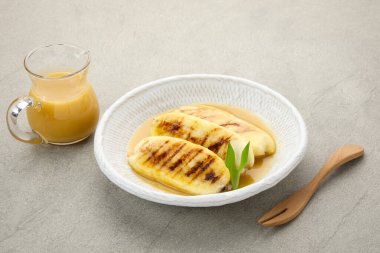 Pisang Gapit or Pisang Epe, grilled banana with palm sugar sauce. Indonesian traditional food. clipart