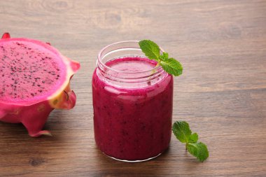 Lezzetli ejderha meyvesi veya pitahaya smoothie ve nane yapraklı taze meyve.