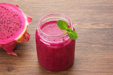 Lezzetli ejderha meyvesi veya pitahaya smoothie ve nane yapraklı taze meyve.