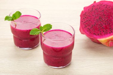 Lezzetli ejderha meyvesi veya pitahaya smoothie ve nane yapraklı taze meyve.