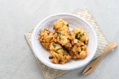 Perkedel Tahu, püre tofu, tapyoka unu, taze soğan, yumurta, tuz ve biberden yapılmış. Beyaz tabakta servis edilir..