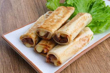 Et ve mozzarella peynirli baharatlı kebap, marul ve biber sosuyla servis edilir.. 