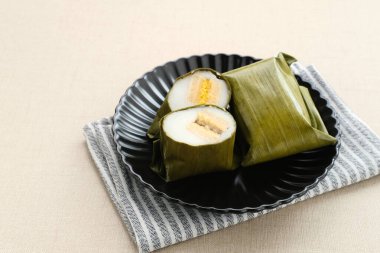 Nagasari, traditional cake from Indonesia, made from rice flour, sago flour, coconut milk and filled with bananas. clipart