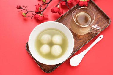 Ronde (Tang Yuan, glutinous rice dumpling balls) is a traditional warm drink made from ginger. The sticky rice balls in wedang ronde usually contain mashed beans and brown sugar.  clipart