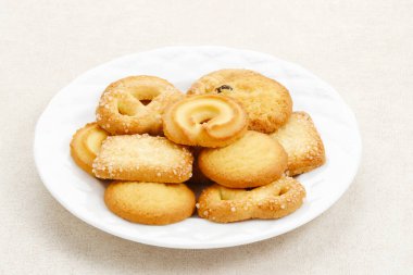 Beyaz bir tabakta servis edilen Danimarka tereyağlı kurabiyeler..