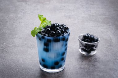 Kelebek sütü köpüklü çay boba tapyoka incileri ve nane garnitürlü.