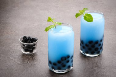 Kelebek sütü köpüklü çay boba tapyoka incileri ve nane garnitürlü.