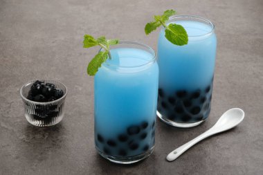 Kelebek sütü köpüklü çay boba tapyoka incileri ve nane garnitürlü.