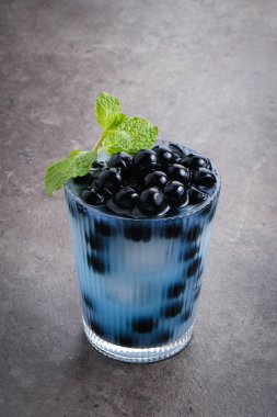 Kelebek sütü köpüklü çay boba tapyoka incileri ve nane garnitürlü.