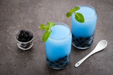 Kelebek sütü köpüklü çay boba tapyoka incileri ve nane garnitürlü.