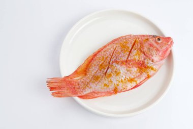 Beyaz tabakta salamura edilmiş balık.