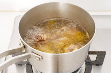 Paslanmaz çelik tencerede kaynamış biftek kaburgaları. 