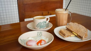 Çeşitli Kopitiam menüleri, kahve, süt çayı, kaya tostu ve onsen yumurtası. 