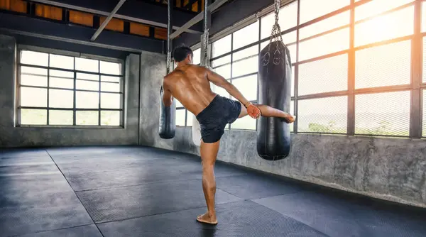 Muay Thai Dövüşçüleri Spor Salonunda Kum Torbasıyla Antrenman Yapıyor Stok Fotoğraf