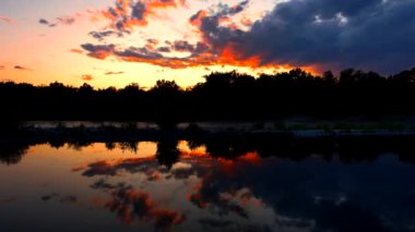 Rüya gibi bir gün batımı, gökyüzünün kırmızısı gibi nehre yansıyor ve eşsiz bir gösteri yaratıyor.