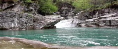  Antigorio Vadisi 'ndeki Marmitte dei Giganti şelaleler ve turkuaz sular arasındaki doğa manzarası.