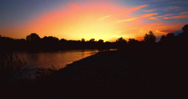 Sonsuz renkler, suyu boyayan günbatımı.