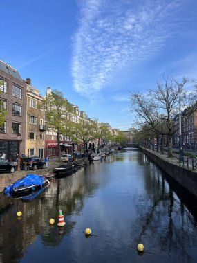 Amsterdam 'ın ikonik kanalları, teknelerin tarihi binaların yanından süzülerek geçtiği, Hollanda kültürünü resimsel şehir manzarasına yansıtan