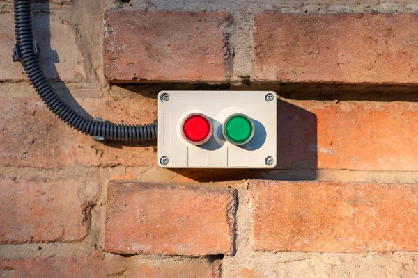 Power on and off buttons placed on a brick wall. Electrical equipment installation concept.