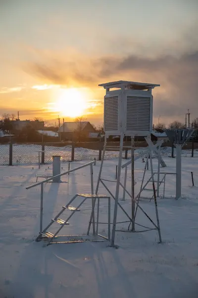 Weather station in the evening during sunset in winter. A device at a weather station for recording the weather close-up.