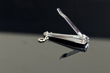 Tırnak makasıyla tırnak kesmek - yakın plan, tırnak makası krom metal, siyah arka plan.